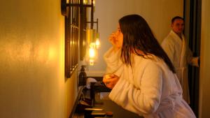 a woman standing in a bathroom looking in a mirror at Mologa River Lodge in Rust de Winter +264 photos