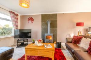 een woonkamer met een bank en een open haard bij Soundwaves House in Bude