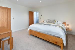 a bedroom with a large bed and a desk at St Aelrhiws Church in Rhiw