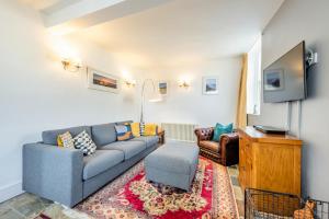 a living room with a blue couch and a tv at South Street Farm in Braunton