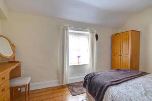 a bedroom with a bed and a window at Ty Newydd in Dolgellau +4 photos