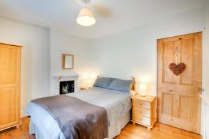 a bedroom with a bed and a wooden door at Ty Newydd in Dolgellau