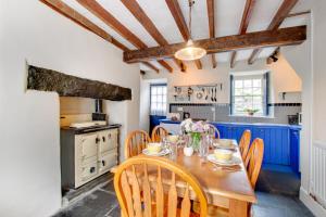 a kitchen with blue cabinets and a wooden table and chairs at Ty Newydd in Dolgellau