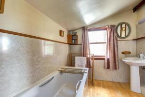 ein Badezimmer mit Badewanne und Waschbecken in der Unterkunft East Cottage in Thwaite
