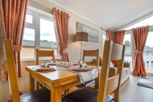 a dining room with a wooden table and chairs at The Garnwen Lodge in Stepaside