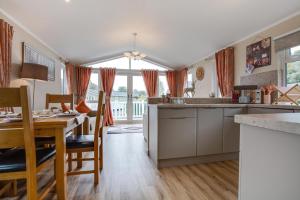 a kitchen with a table and a dining room at The Garnwen Lodge in Stepaside +2 photos