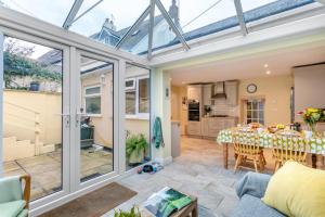 a conservatory extension with a dining room and a table at Drum Cottage in Appledore