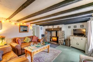 a living room with a couch and a fireplace at Drum Cottage in Appledore
