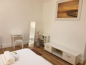 een slaapkamer met twee bedden, een bureau en een spiegel bij Cosy Family Flat in Elswick