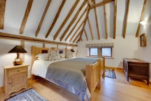 een slaapkamer met een groot bed en een houten vloer bij Birdsong Barn in Westfield