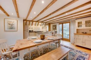 een eetkamer met een houten tafel en stoelen bij Birdsong Barn in Westfield
