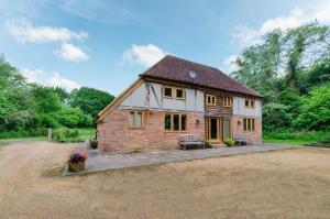 een groot bakstenen huis met een patio in de tuin bij Birdsong Barn in Westfield