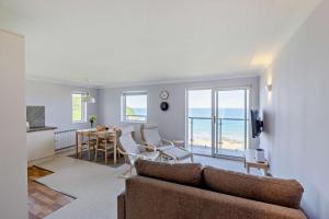 Una sala de estar con un sofá y una mesa con sillas. en Flat 9 Clifton Court, en Croyde