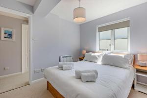 Un dormitorio con una gran cama blanca con dos almohadas. en Flat 9 Clifton Court, en Croyde 19 fotos más