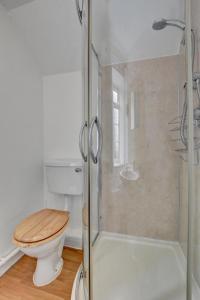 ein Badezimmer mit Toilette und Glasdusche in der Unterkunft Pusehill Cottage in Westward Ho + 15 Fotos
