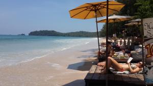 a group of people sitting on the beach at JJ Beach Resort & JJ Seafood in Ko Phayam