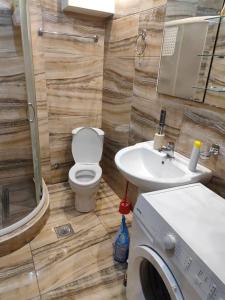 a bathroom with a toilet and a sink and a washing machine at Apartment Majestic in Budva