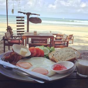 a plate of food with an egg and bread on the beach at JJ Beach Resort & JJ Seafood in Ko Phayam +37 photos