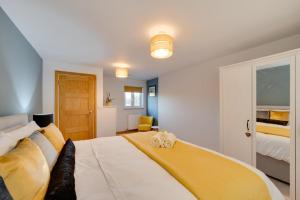 a bedroom with a large white bed with yellow pillows at Drws Nesa in Tregaron +10 photos