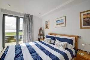 Un dormitorio con una cama y una ventana grande en 2 Ocean Point, en Braunton