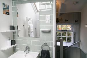 ein Badezimmer mit Waschbecken und Spiegel in der Unterkunft Molly Muppet in Mousehole