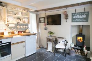 eine Küche mit Kamin und Herd in der Unterkunft Molly Muppet in Mousehole + 11 Fotos