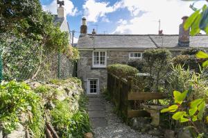 ein Steinhaus mit einem Weg dorthin in der Unterkunft Molly Muppet in Mousehole