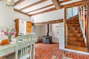 a living room with a table and a fireplace at Corner Cottage - Kent in Benenden +17 photos