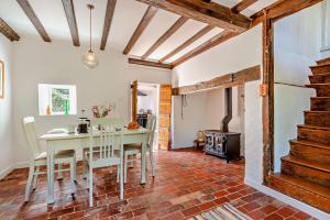 a dining room with a table and chairs and a stove at Corner Cottage - Kent in Benenden