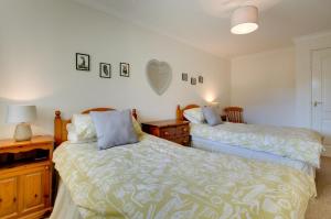 1 dormitorio con 2 camas, tocador y espejo en Flat 24 Clifton Court, en Croyde 12 fotos más