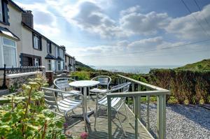 a table and chairs on a balcony with a view of the ocean at Seaview Cottage in Mortehoe