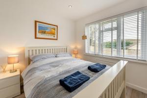 a bedroom with a bed with two blue towels on it at Seashells in Georgeham