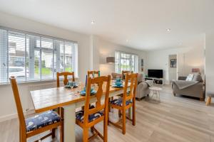 a dining room and living room with a table and chairs at Seashells in Georgeham
