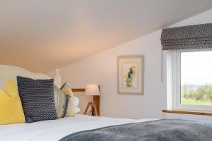 Un dormitorio con una cama blanca y una ventana. en Owl House, en Beckley
