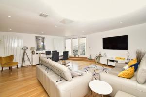 ein Wohnzimmer mit weißen Möbeln und einem Flachbild-TV in der Unterkunft 3 Little Beach in Woolacombe