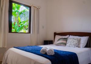 a bedroom with a bed with two towels on it at Pousada Pitaya Maresias in Maresias +36 photos