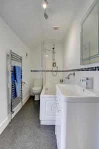 a white bathroom with a sink and a toilet at Cross Farm Cottage in Braunton +16 photos