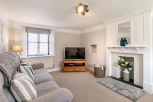 a living room with a couch and a television at Cross Farm Cottage in Braunton