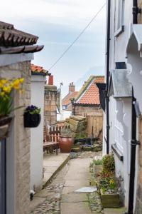 an alley in a town with houses and a bench at Storm Cottage in Robin Hood's Bay