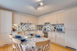 eine Küche mit einem Tisch und Stühlen darin in der Unterkunft Elterwater Apartment in Bowness-on-Windermere