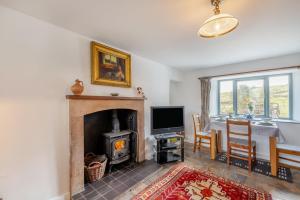un salon avec une cheminée et une table de salle à manger dans l'établissement The Cottage - Bellman House, à Crook
