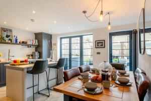 a kitchen and dining room with a wooden table and chairs at Thorncliffe Mews in Bishops Tawton