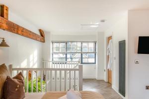a room with white walls and a staircase with a crib at Thorncliffe Mews in Bishops Tawton