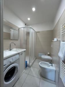 a bathroom with a washing machine and a toilet at al mare casa vacanza in Rossano Stazione