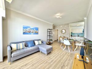 a living room with a couch and a table at Quarteira Central Beach 5 by Homing in Cavacos
