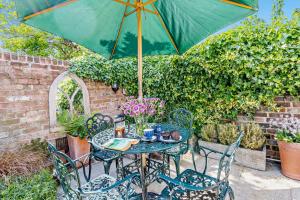 a table and chairs with a green umbrella at Crown Cottage - Rye in Rye
