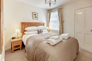 a bedroom with a large bed with white pillows at Crown Cottage - Rye in Rye