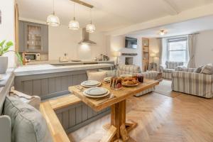 a kitchen and living room with a table with food on it at Mole End in Fowey