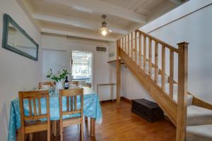 een eetkamer met een tafel en een trap bij Wills Cottage in Lower Boscaswell +16 foto's