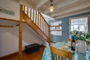 een eetkamer met een tafel en een trap bij Wills Cottage in Lower Boscaswell